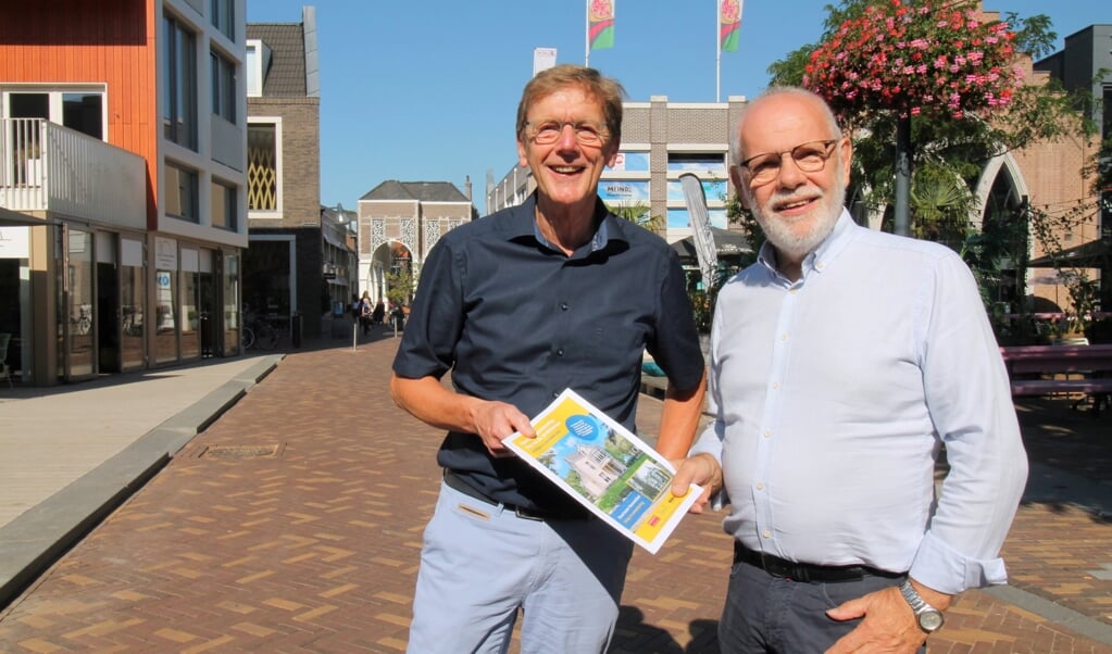 Johan Huibers (links) en Hennie Henzen voor DownTown op het Thoomesplein met de krant voor Open Monumentendag die vorige week bij De Rijnpost bezorgd werd.