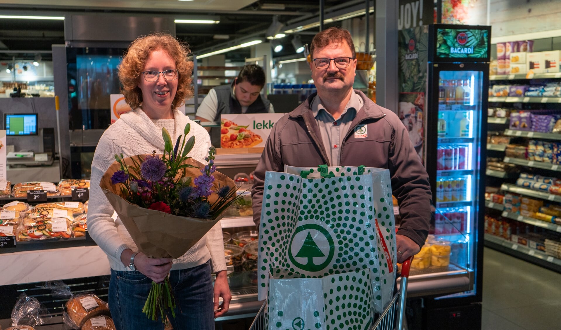 Rhea van Gijlswijk met Gerrie Hetterrscheid, de boodschappen die ze won én de mooie bos bloemen die ze kreeg van Spar City. 
