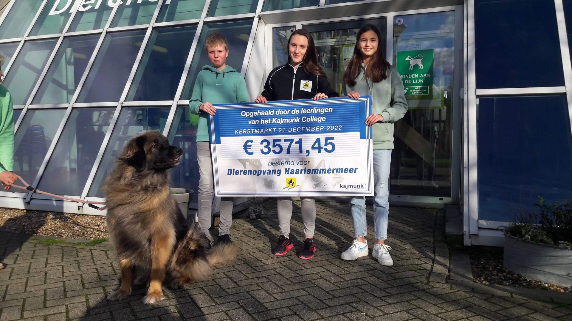 Leerlingen Thomas Versteeg (links) en Madelief Koudhoofd (rechts) overhandigden de cheque van ruim 3500 euro aan de dierenopvang.