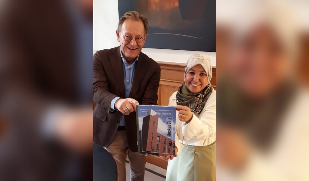 Burgemeester Koos Janssen kreeg onlangs van Fatima Azoum een exemplaar van haar boek over de Moskee Zeist.