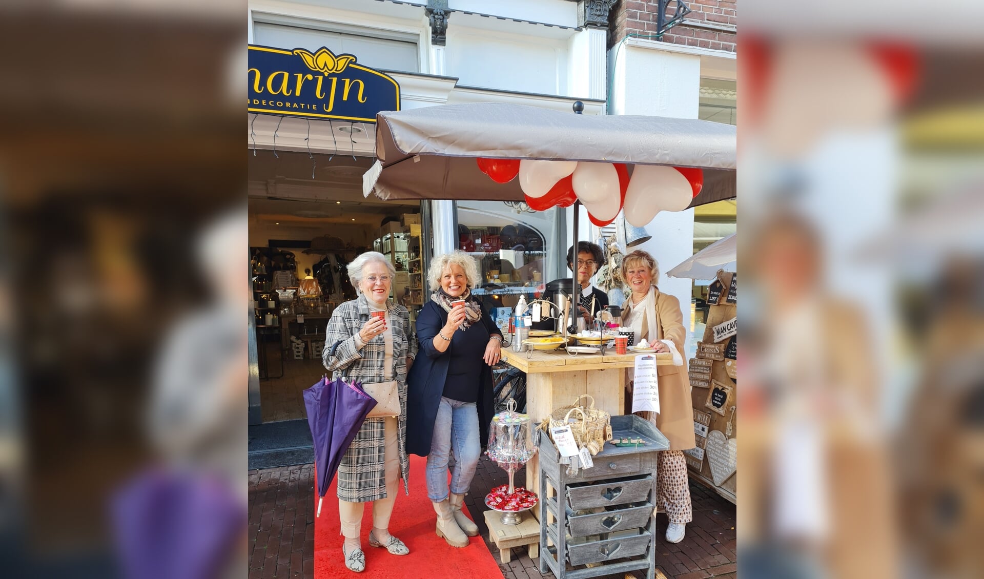 Elly Mulder (rechts) met enkele bezoeksters voor haar winkel ‘Rozemarijn Wonen’ aan de Langstraat
in Barneveld.