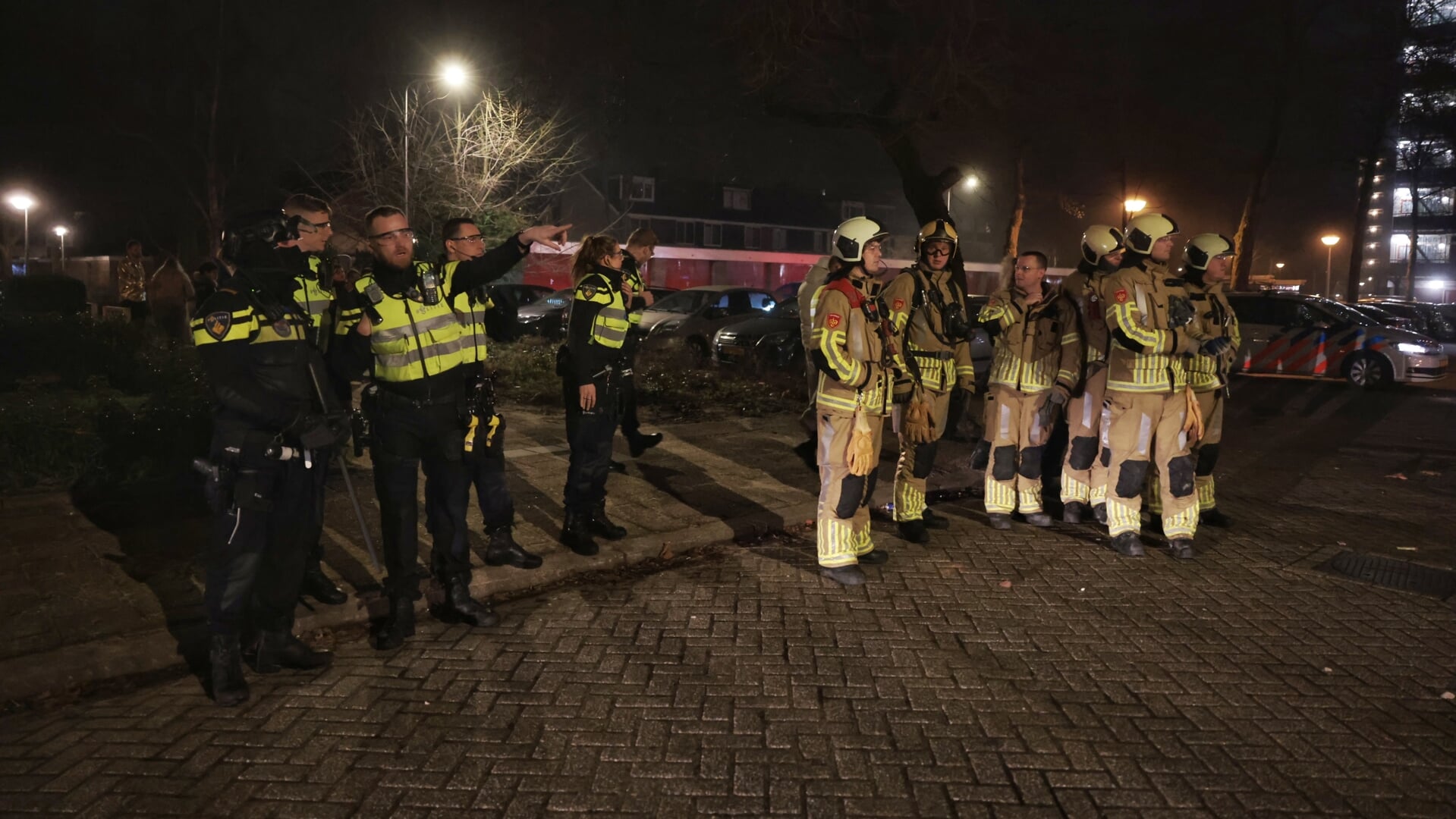 Een foto uit de nieuwjaarsnacht. Een grimmige situatie in Zeist: de brandweer moest zich terugtrekken terwijl de politie wachtte op versterking.