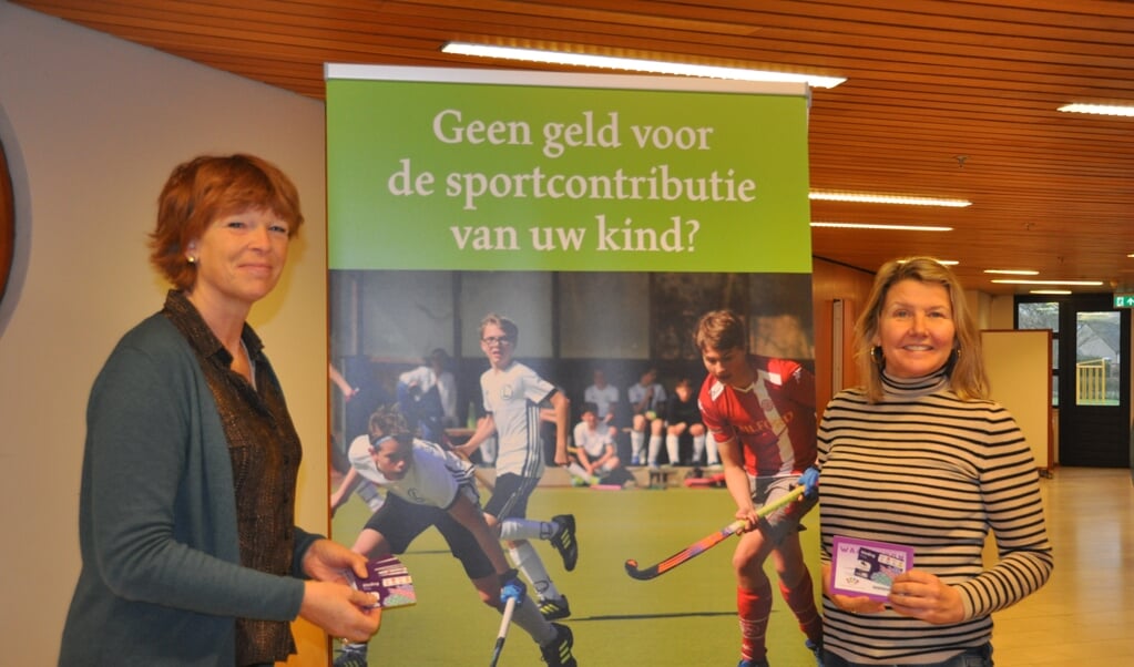 Jacqueline Franssens en Esther Bruijns met de kledingbonnen voor (nieuwe) cliënten van Stichting Leergeld.