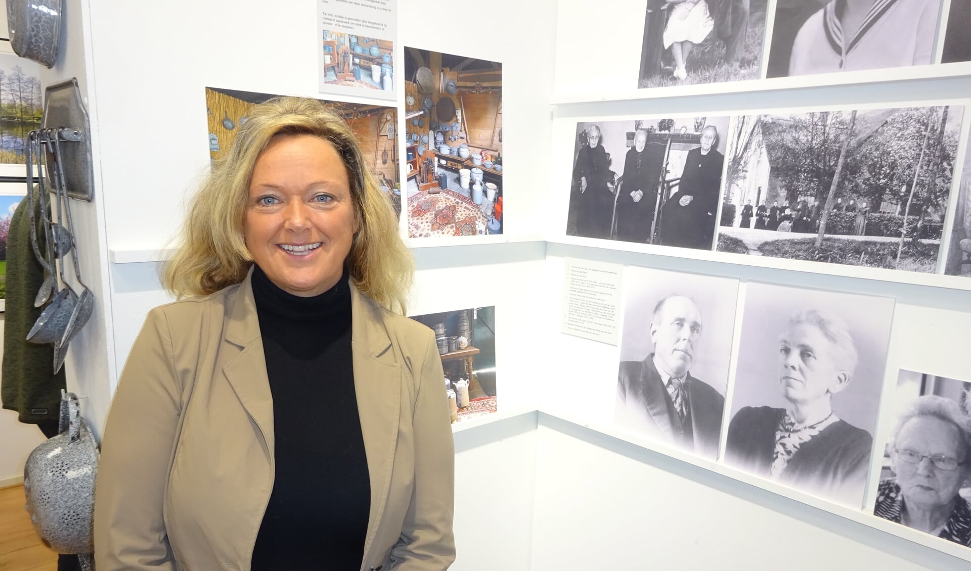 Liesbeth van den Dool opende de expositie. Zij staat bij een wand met familiefoto's van de familie Van den Dool.