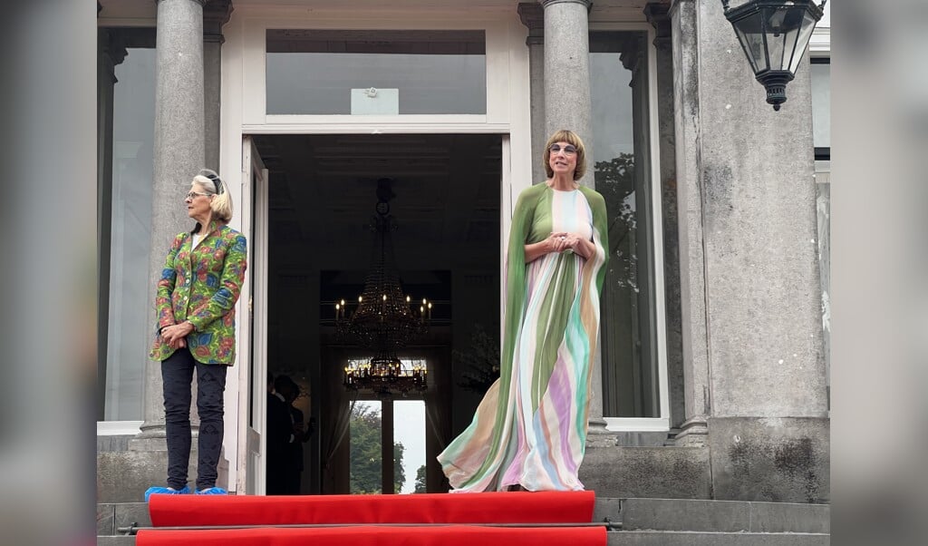 Samensteller van de expositie, Nicole Uniquole (rechts), en historica Reinildis van Ditzhuyzen op het bordes, de officiële ingang van de tentoonstelling.