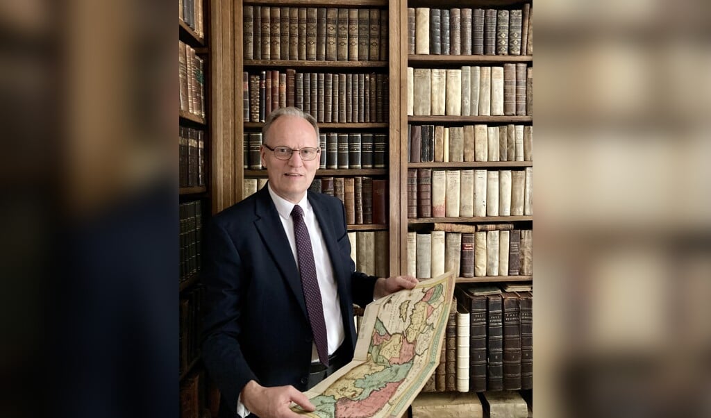 Taxateur Arie Molendijk met een parel van een boek in zijn handen.