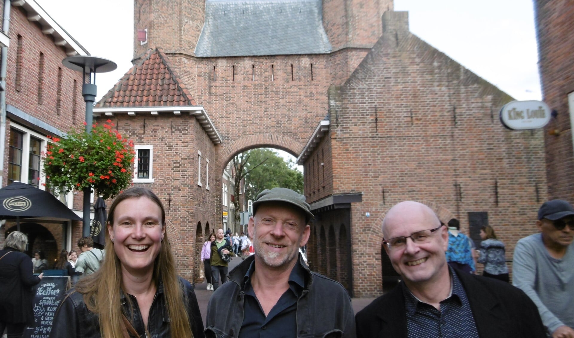 Voor de Kamperbinnenpoort staan Rosanne van der Lugt, Bas Cloo en Max Griebling, drie docenten van de Volksuniversiteit.