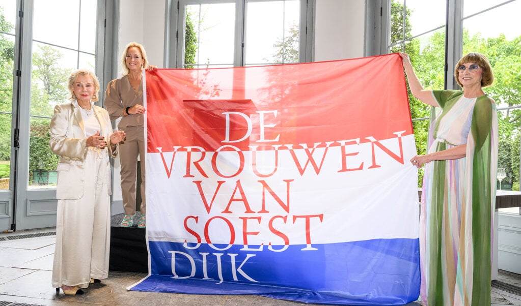 Van links naar rechts Maya Meijer-Bergmans, eigenares van paleis Soestdijk, prinses Margarita de Bourbon de Parme en curator Nicole Uniquole met de vlag die verwijst naar de expositie.
