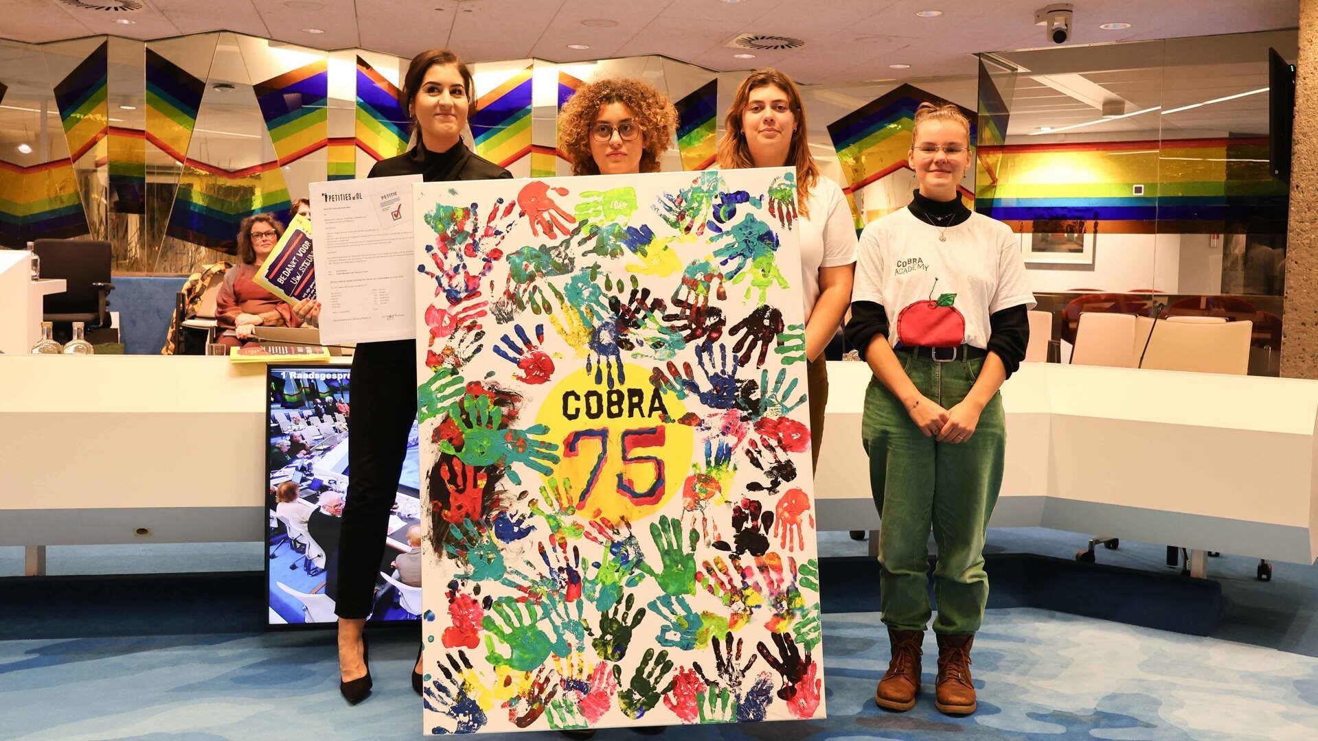 Overhandiging van de petitie door de Cobra Academy-leden Julia Kemp, Lisa le Grand, Appel Toussaint aan de voorzitter van het raadsdebat Saloua Chaara (links)