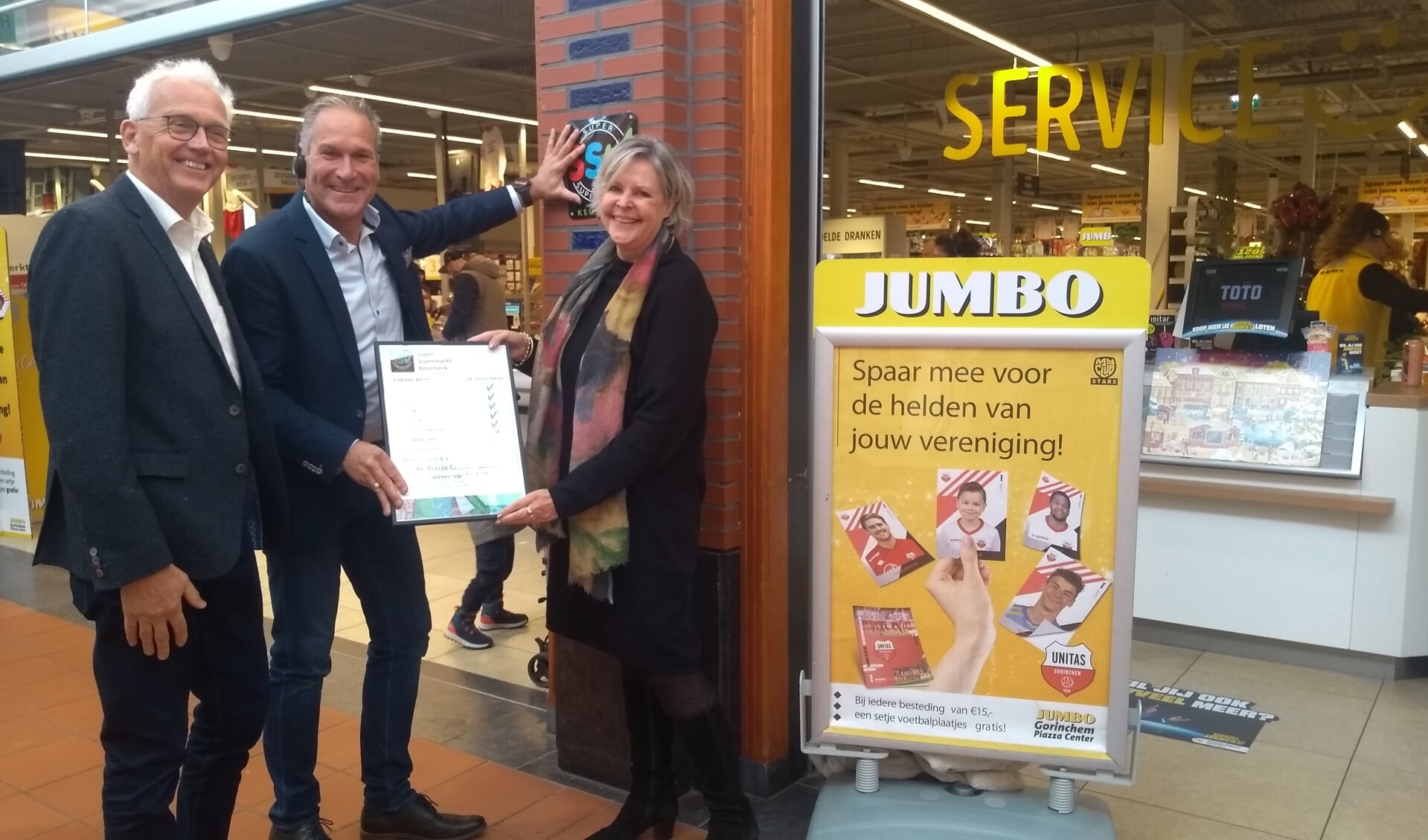 Supermarkteigenaar Wirner van Aanholt ontvangt het keurmerk uit handen van wethouder Attie Mage en Bram de Jong