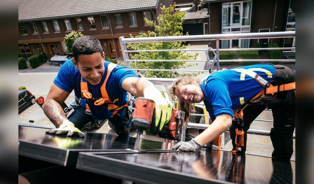 Medewerkers van Zonnet leggen zonnepanelen