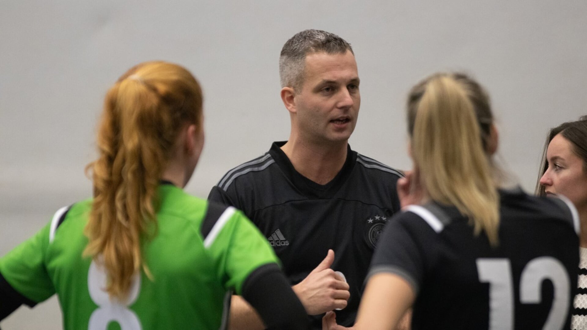 Coach Roy Kroon spreekt de dames toe in een time-out
