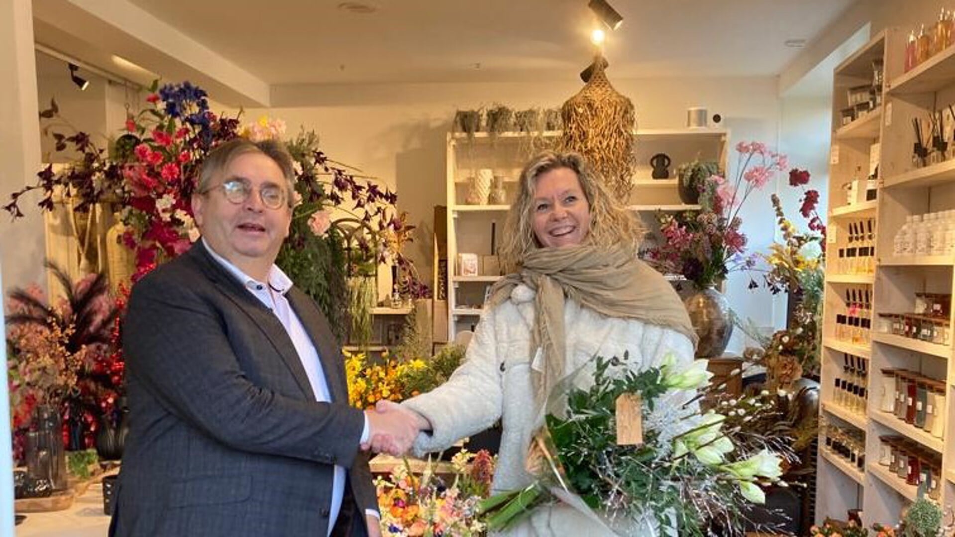 Wethouder Gerard van Deelen overhandigde een boeket bloemen aan interieurstylist Bianca Seegers van halte B