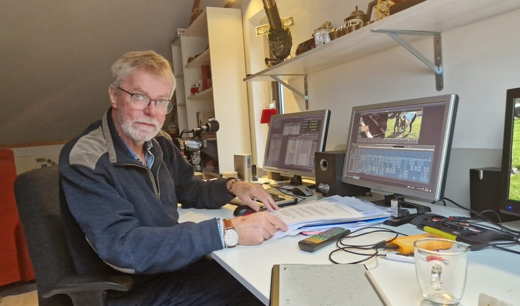 Klaas Wijbenga op zijn werkplek met een stapel documenten die belangrijk waren bij het maken van de documentaire