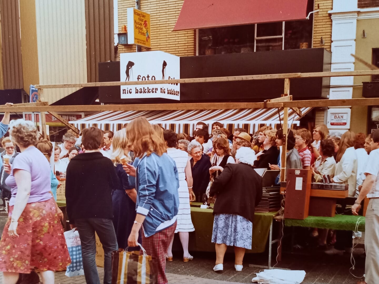 Drukte voor de winkel van Foto Nic. Bakker tijdens een zomerbraderie in de Hoofdstraat in 1981.
