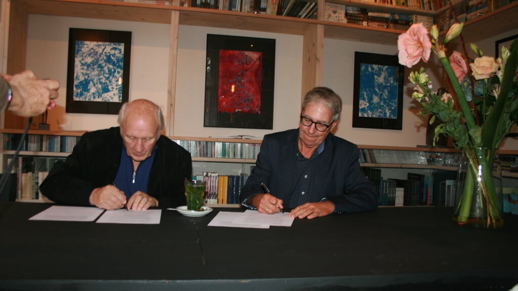 Herman van Veen (l) en Roelof Meijer ondertekenen de samenwerkingsovereenkomst.