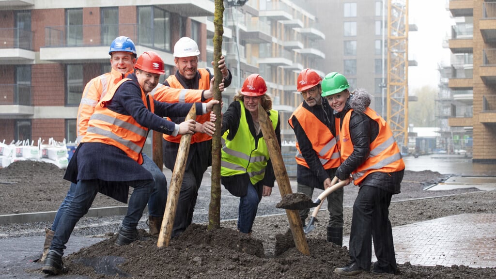 Wethouder Floor Gordon plant met andere betrokken partijen de eerste boom in een park dat op het dak van een parkeergarage in nieuwbouwproject Olympiade wordt aangelegd.