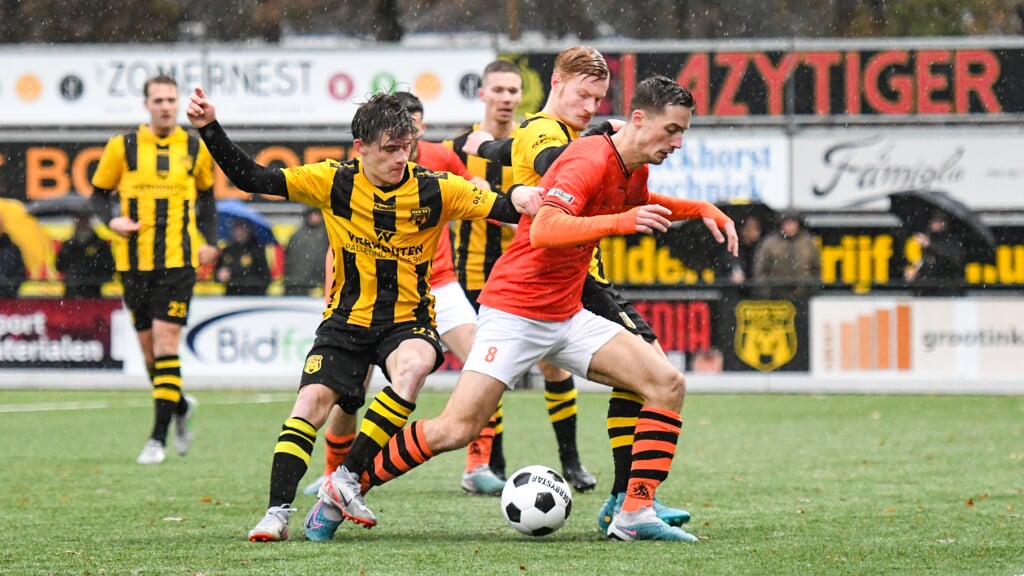 Typerend wedstrijdbeeld: Owen Müller en Maarten van Dijk jagen Jesse Buitenhuis op.