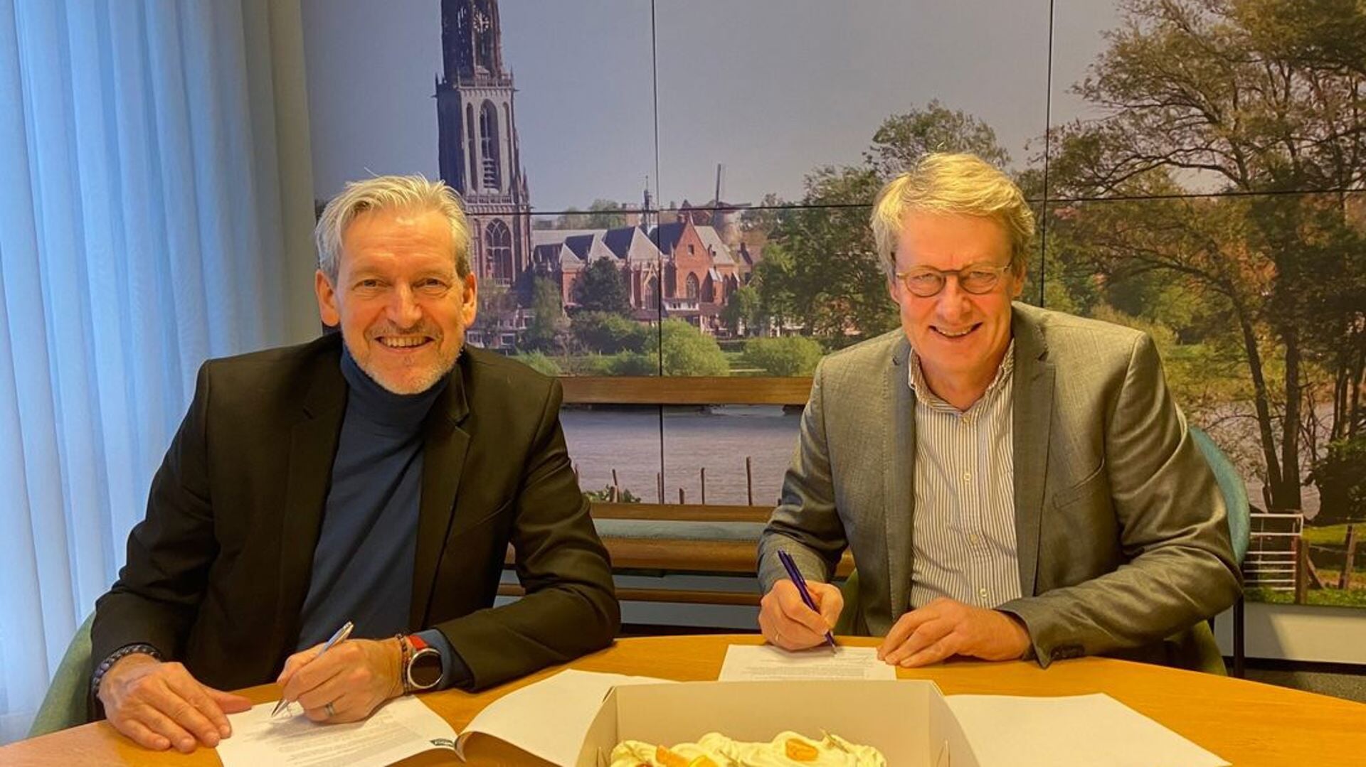 Burgemeester Hans van der Pas (l) en Jeroen Cnossen, algemeen directeur van de Koninklijke BDU, ondertekenen het contract. 