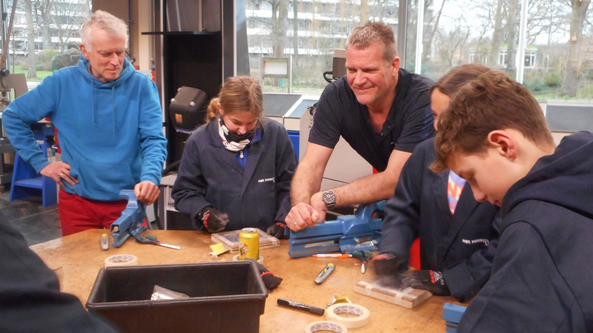 Sjors Dijk (links) en projectleider Jaap van 't Land met een basisschoolklas in één van de werkplaatsen op Het Perron.