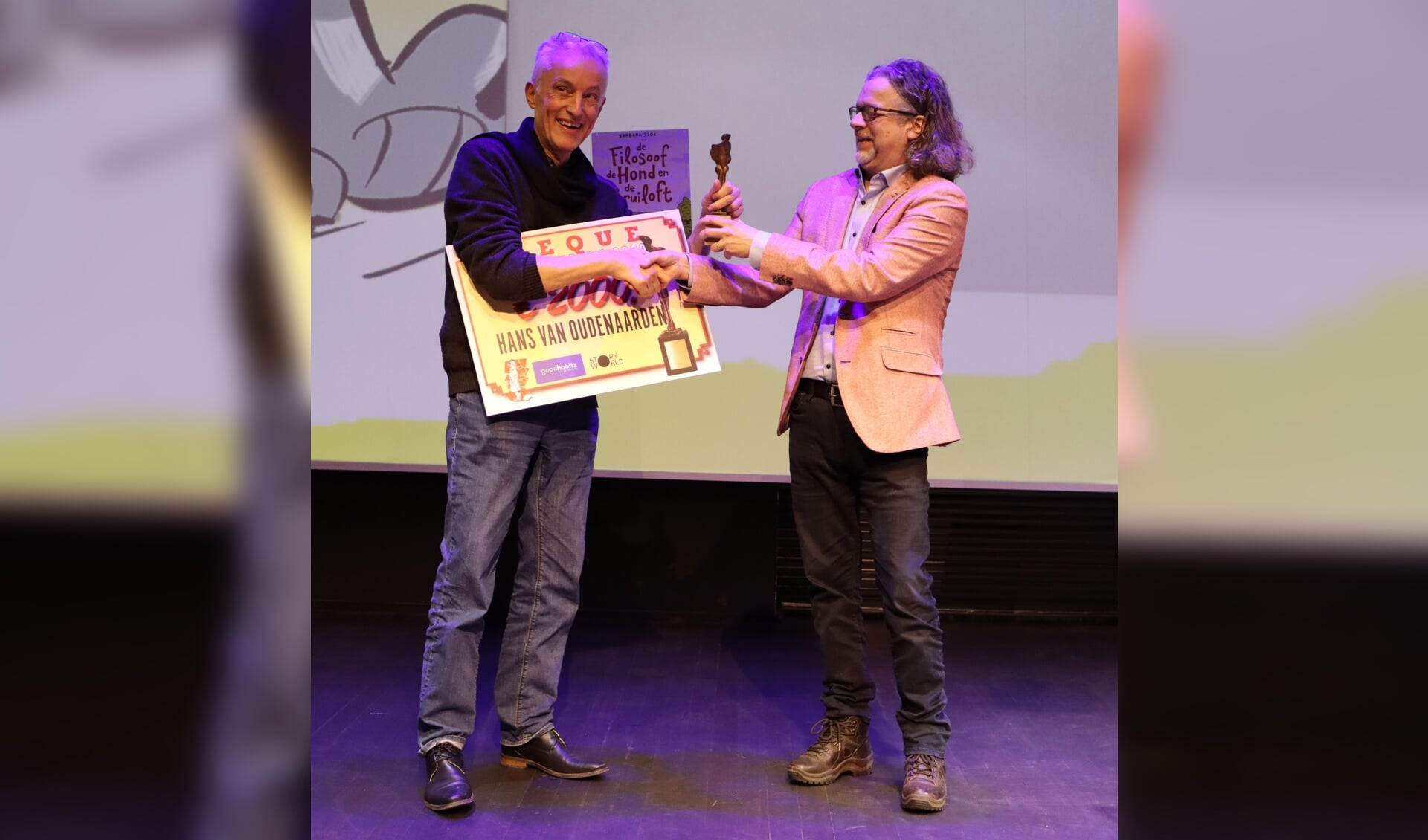 Hans van Oudenaarden ontving van de Stripmaker des Vaderlands Herman Roozen (r) de Stripschapprijs.