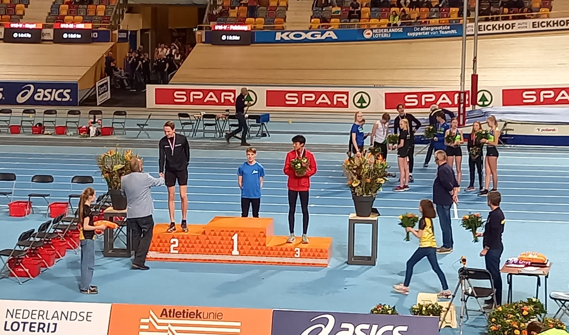Nathan Houwaard neemt de zilveren medaille die hij in de wacht sleepte op de 3000 meter in ontvangst.