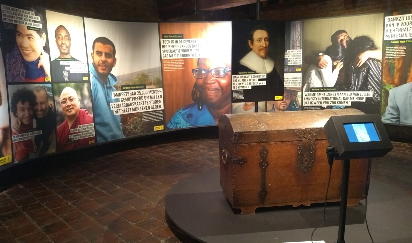 Foto's van politieke gevangenen rondom de kist van Hugo de Groot