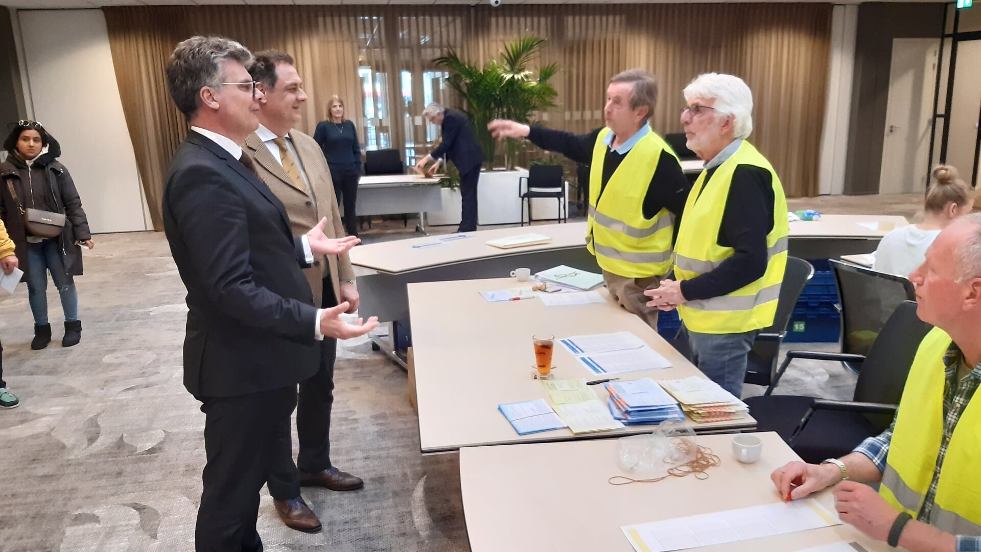 Commissaris van de Koning Oosters (links) in gesprek met leden van het stembureau in het Huis van Leusden.