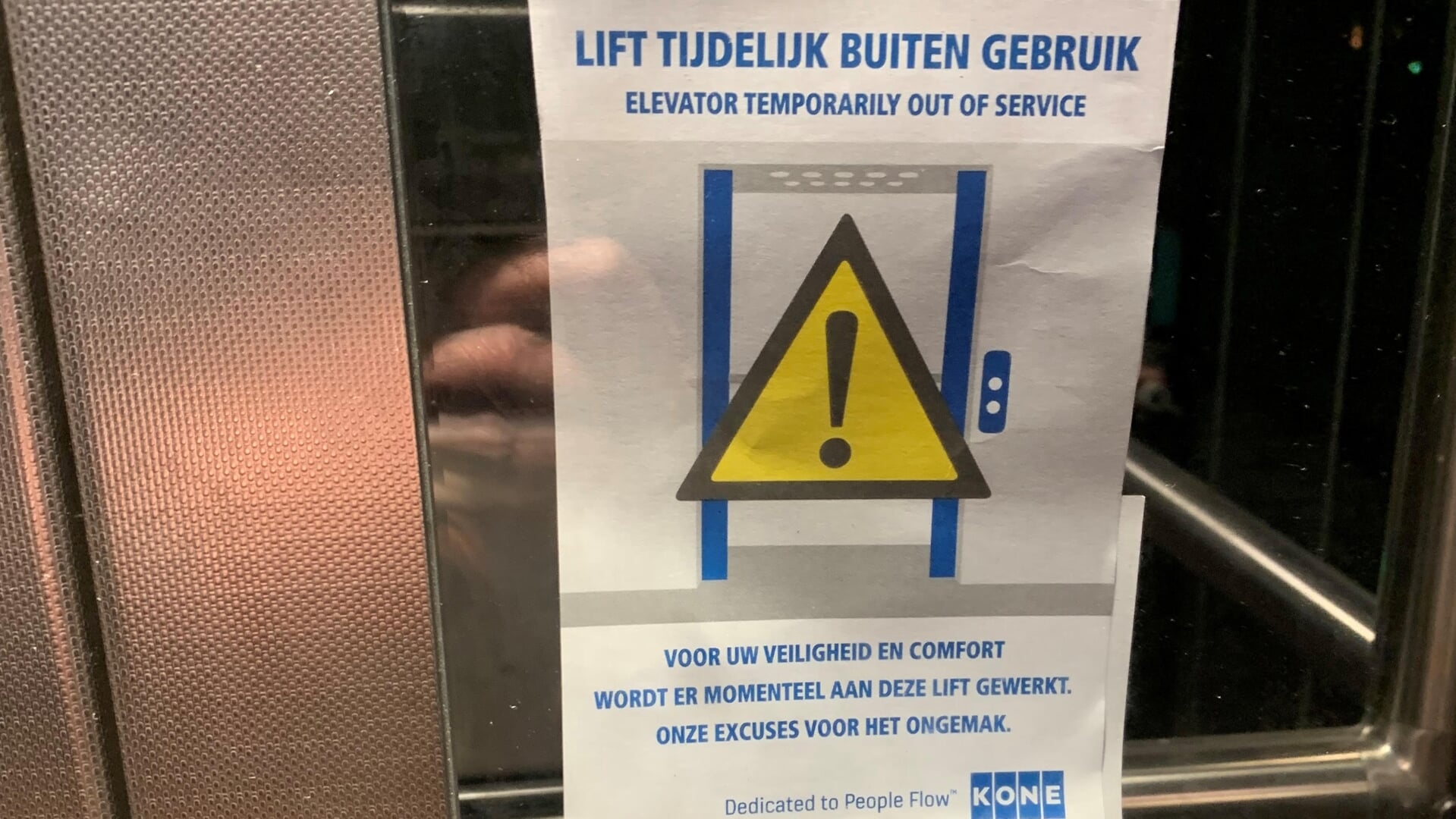 Een sticker op de liftdeur met 'Excuses, lift is buiten dienst' is de enige melding die wordt gedaan.