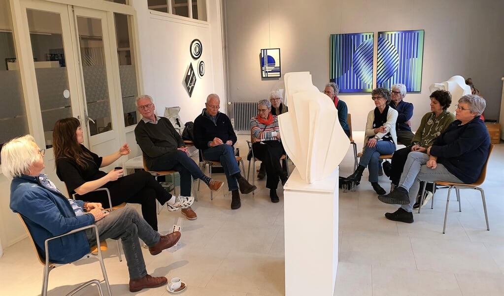 Joop Hollanders (links) en naast hem Dphne Glasmacher vertellen aan de gastvrouwen en heren over hun tentoongestelde werken.
