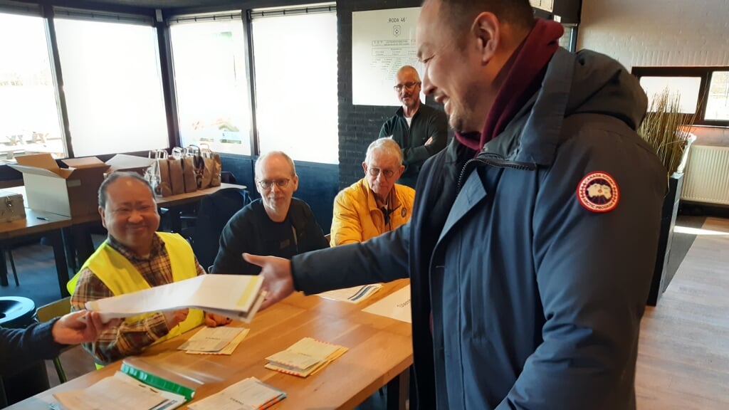 David (in geel hesje) heeft zichtbaar plezier in zijn werk op het stembureau. 