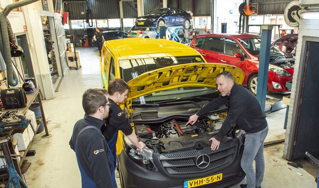 Jos Bouw (rechts) met autotechnici Patrick Mulder (links) en Dennis Struik bij een elektrische auto.