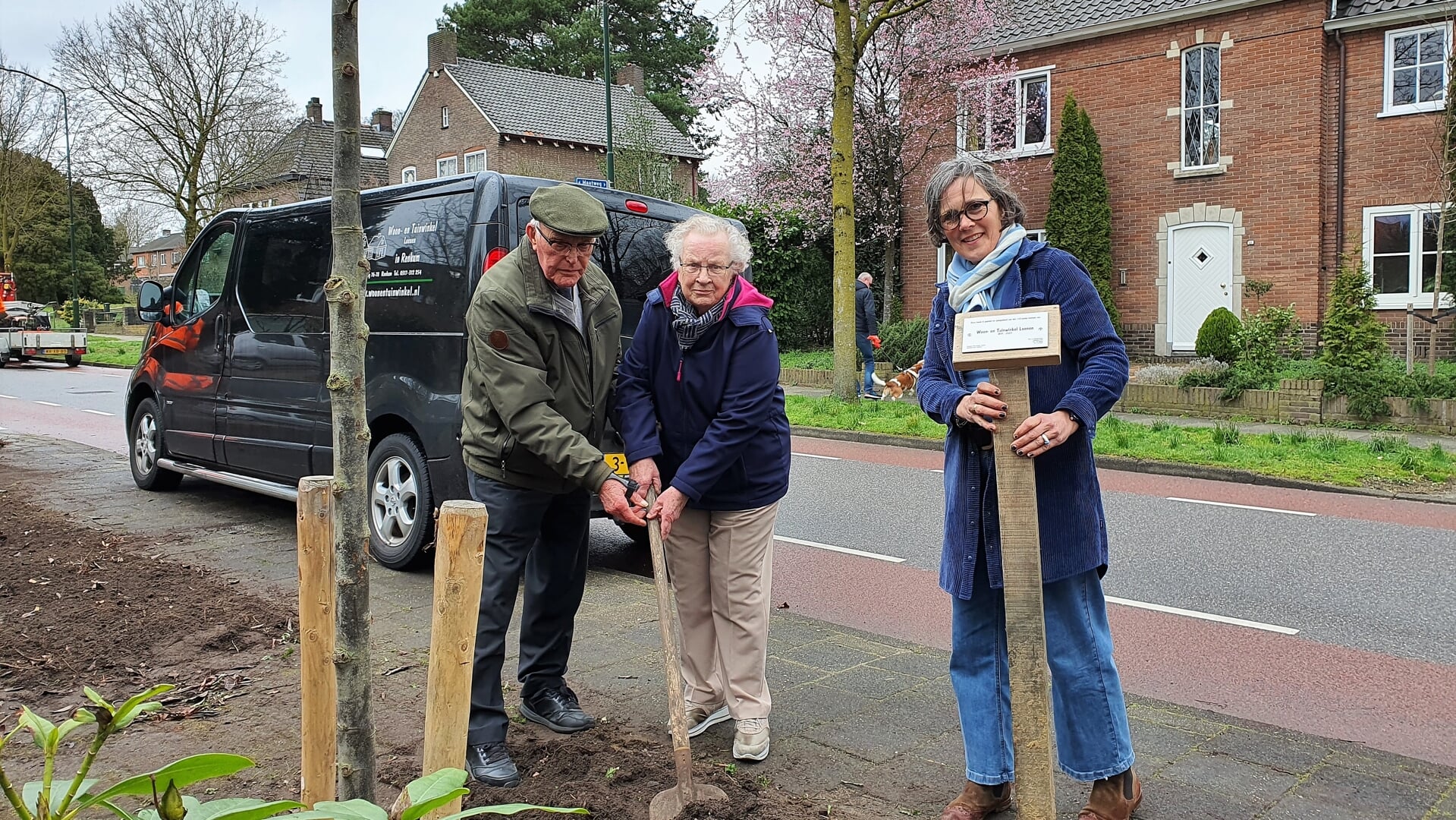 Jan en Willy Loenen planten aan de Groeneweg de jubileumboom die Tuin- en Woonwinkel Loenen aan 'Renkum' schenkt. Rechts Ina Bakker-Loenen.