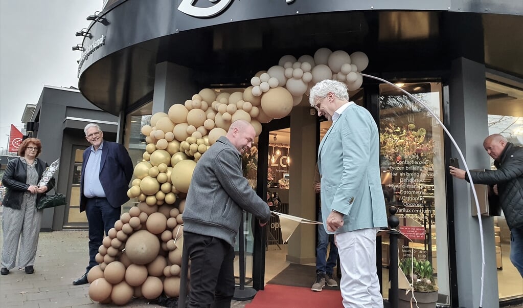 Vitesse-icoon Nicky Hofs verricht, onder toeziend oog van Hans Polman, de opening van de nieuwe winkel van Rijks Optiek in Oosterbeek.