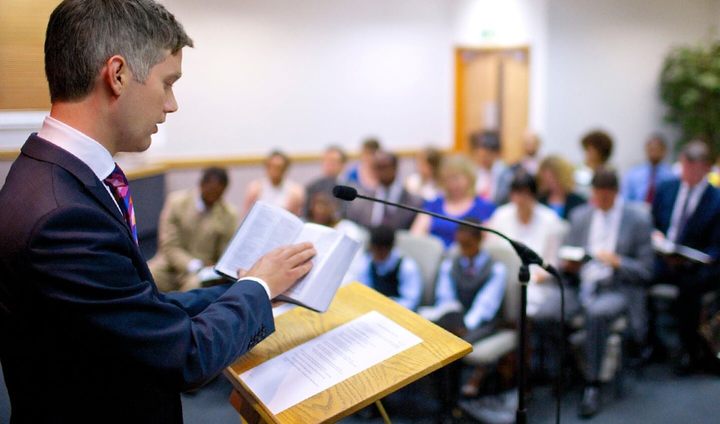 Een bijeenkomst van de Jehovah's Getuigen, waarin net als in de koninkrijkszaal in Barneveld een ouderling voorgaat.