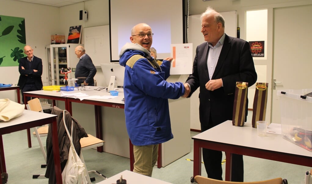 Ben Kolster, bestuurslid Volksuniversiteit Wageningen feliciteert een cursist met behaald certificaat.                                        