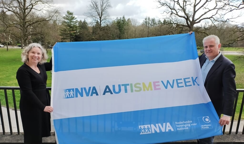 Caroline Verkerk, directeur van de NVA en het AutismeFonds en wethouder Krischan Hagedoorn
hijsen samen de Autismeweek vlag