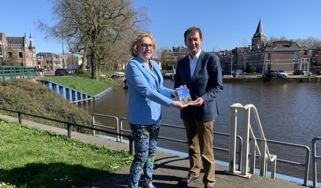 Rob van Muilekom, gedeputeerde van de provincie Utrecht, kreeg de nieuwe wandelgids van Anastasia van der Lugt, directeur van de Stichting Oude Hollandse Waterlinie (SOHW), tijdens een wandeling in Woerden.