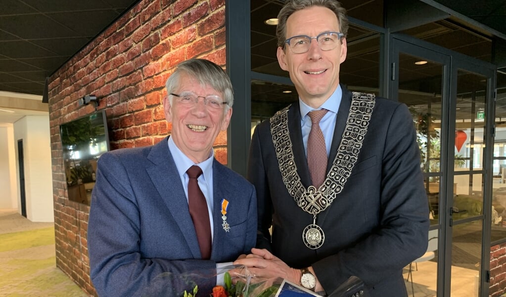 Victor Frequin ontvangt de koninklijke onderscheiding uit handen van burgemeester Tjapko Poppens.