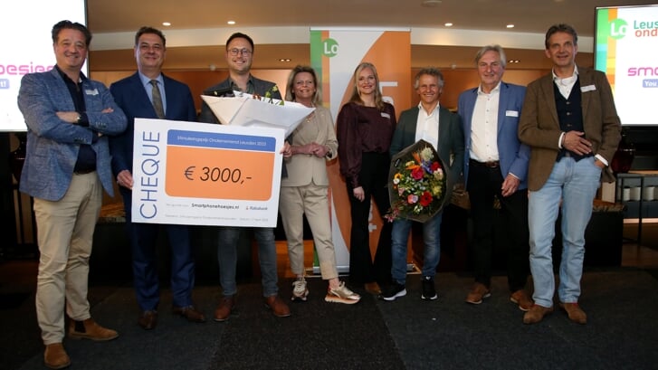 De winnaar van de Ondernemersprijs 2023, Smartphonehoesjes.nl, geflankeerd door burgemeester Bouwmeester, de organisatie van het gala en gastspreker Jan Lammers.