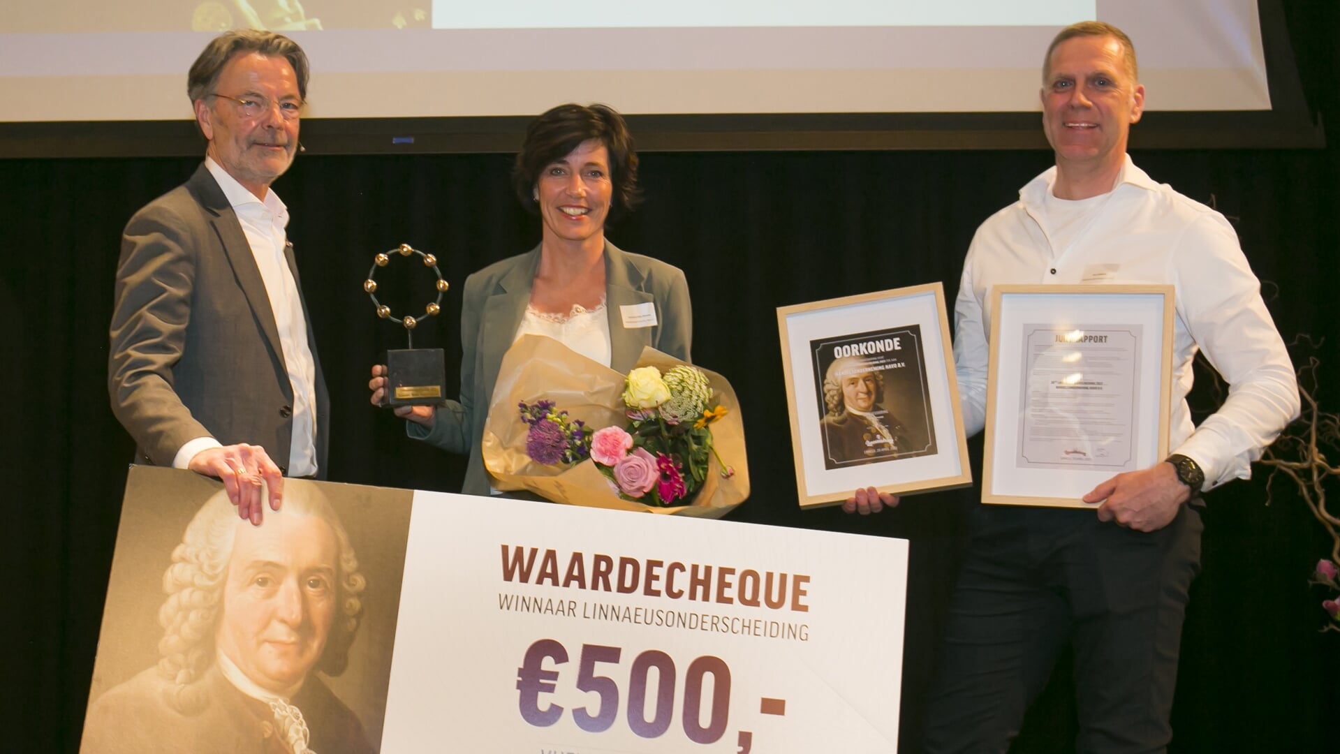Joost Fraanje overhandigt de Linnaeusonderscheiding aan Annemieke Zwiers-Vos en Jan Zwiers van Havo.