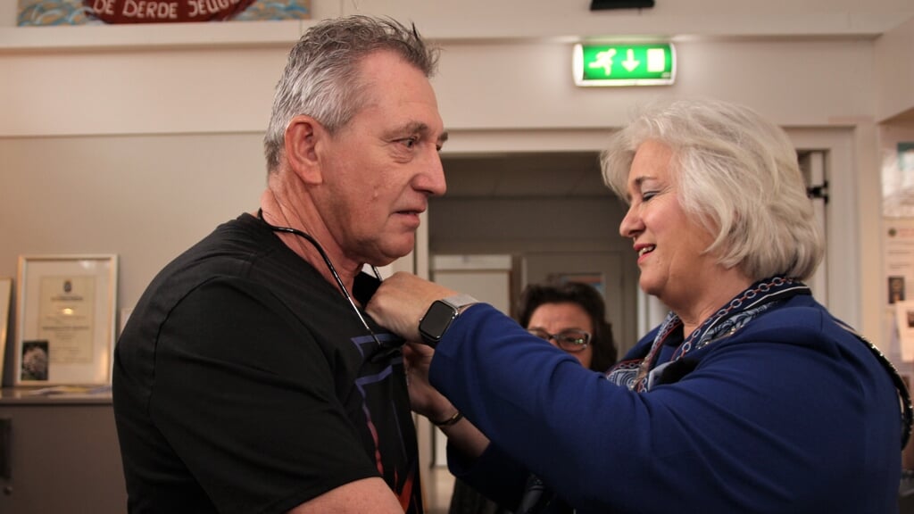 Kees van der Peijl krijgt door burgemeester Schuurmans zijn zijn oorkonde opgespeld.