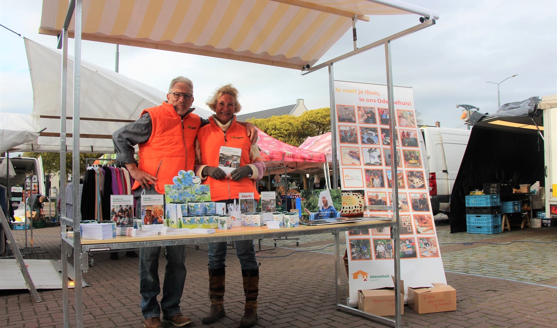 Tom van Berkel en Trudy Slakhorst, enthousiaste vrijwilligers van het Odensehuis, op de markt in Oosterbeek..