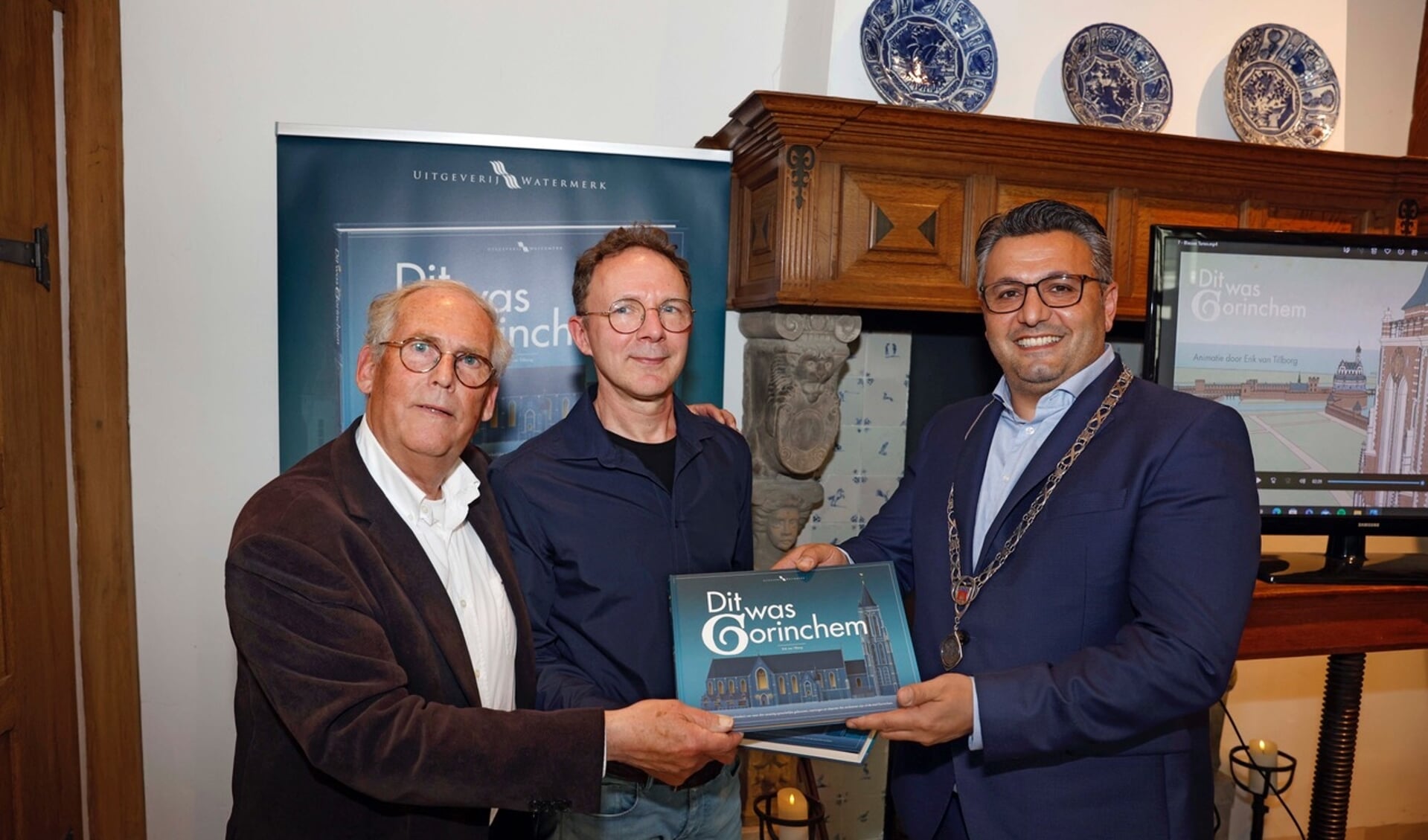 Auteur Erik van Tilborg en uitgever Peter Egge overhandigen het eerste exemplaar aan wethouder Fatih Polatli