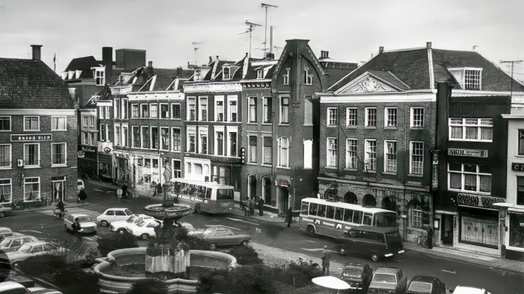 De Grote Mark, in het centrum van Gorinchem met in het midden de fraaie fontein. Het bankgebouw met lichtreclame is duidelijk zichtbaar. De bus staat voor onze ouderlijke woning.