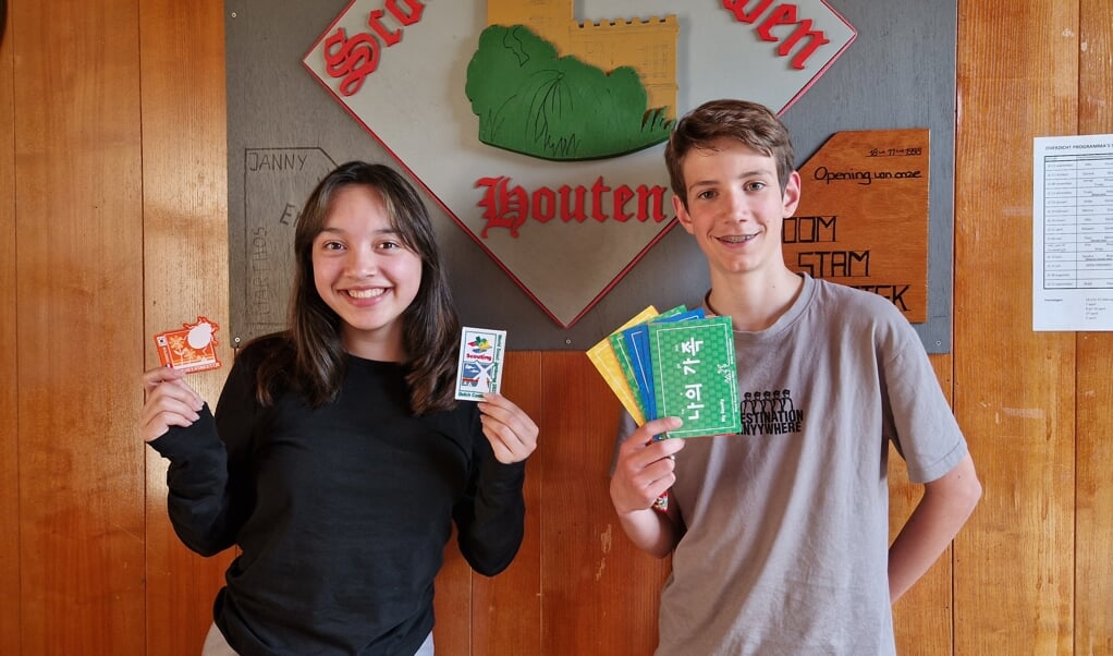 Linh-Dan met ruil-insignes en Thom toont een kaartenset met vertaalde zinnen