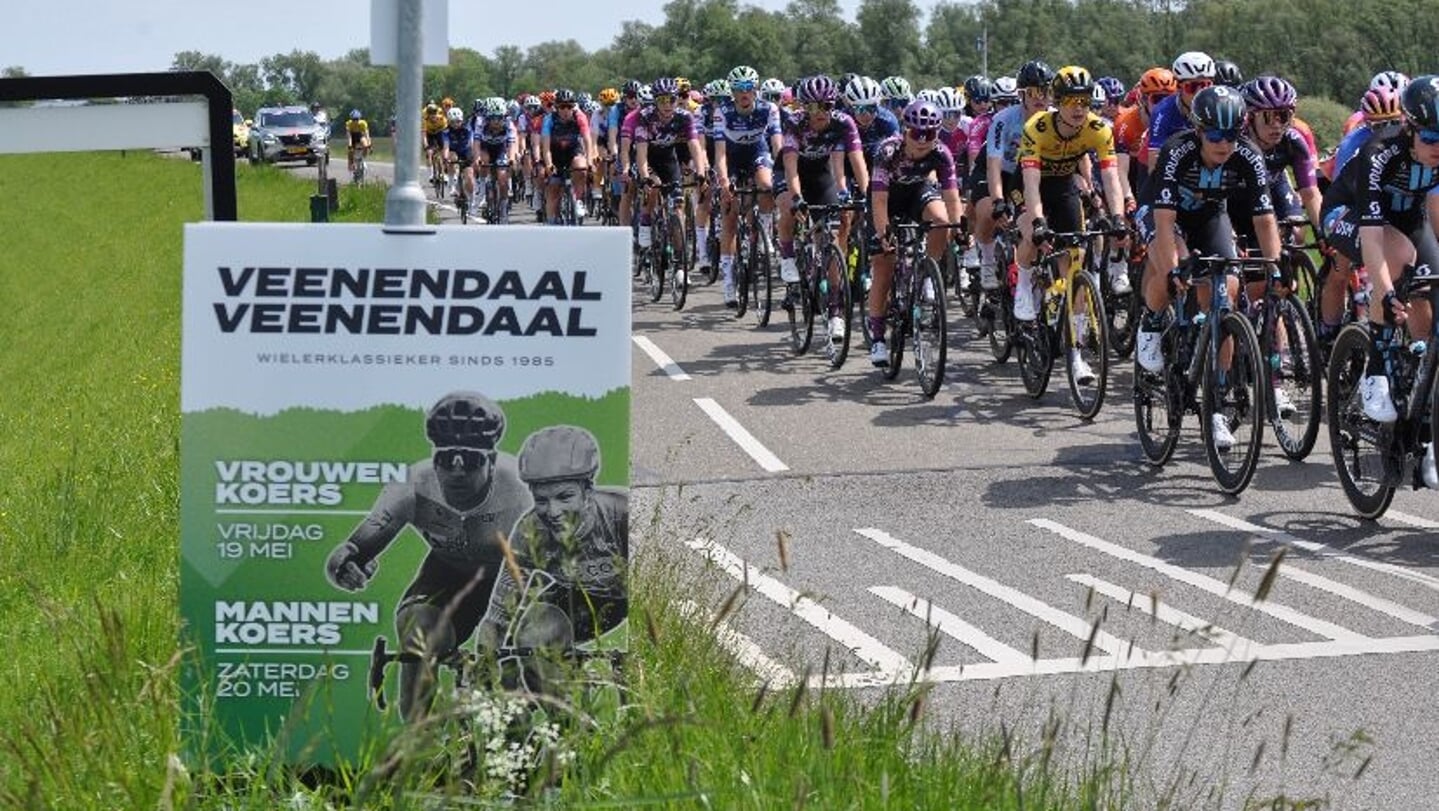 De vrouwen wielrenners passeren één van de vele borden die Veenendaal-Veenendaal in de regio aankondigen.