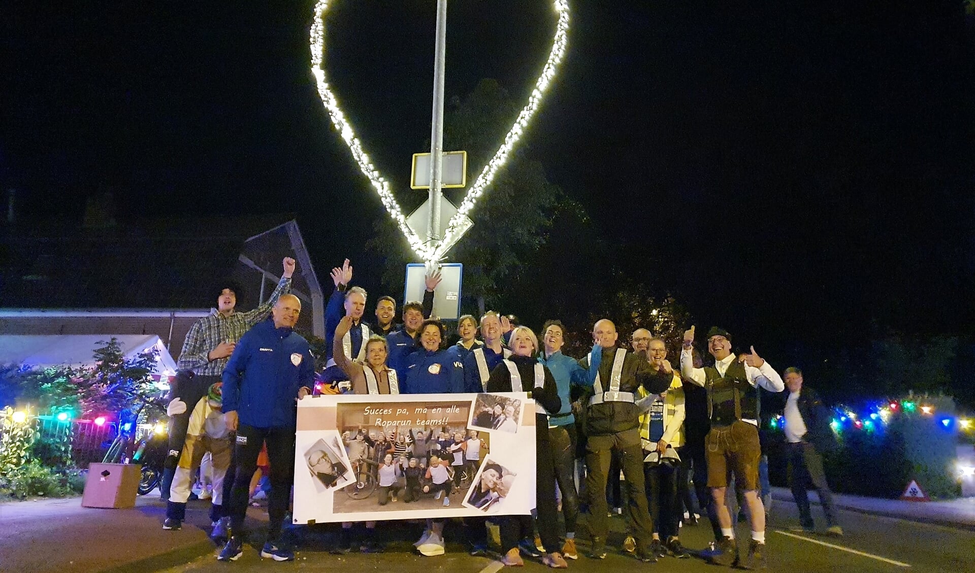 Roparun Team Climax Ede poseert, op weg naar het eindpunt Rotterdam, bij het verlichte hart, het fraaie verlichte symbool bij 'het steunpunt Bennekom' aan de Edeseweg 40A.