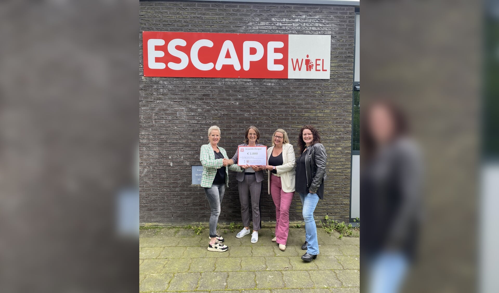 De moeders ontvangen de cheque van Jannetta van der Ziel.