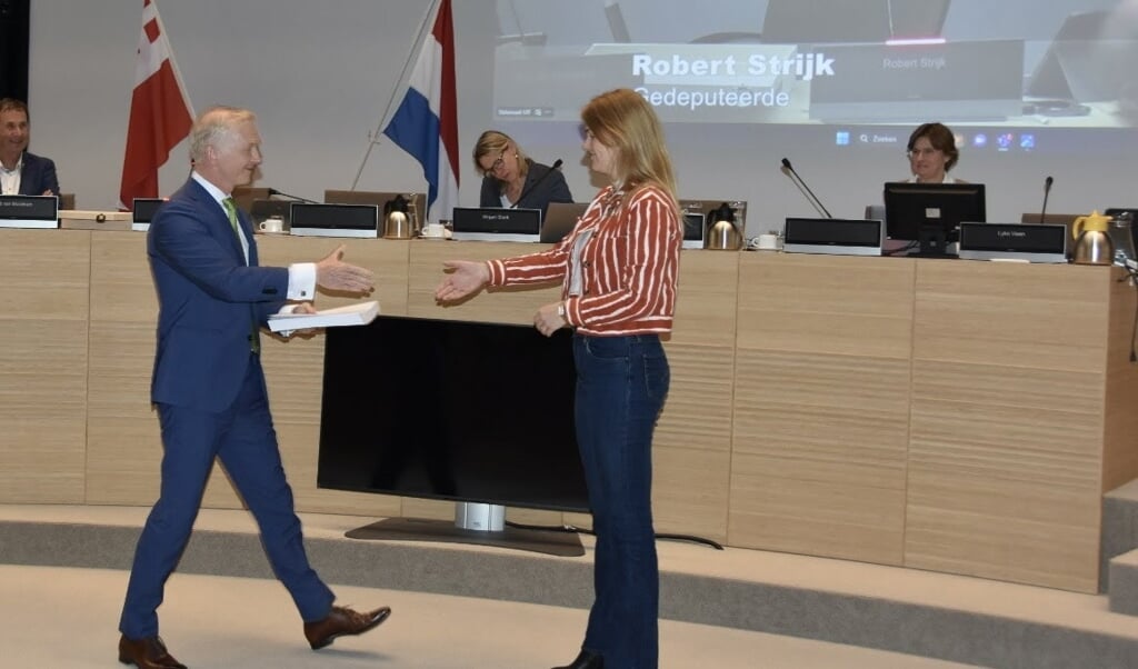 Gedeputeerde Robert Strijk overhandigt de Jaarrekening 2022 aan Commissievoorzitter Lyke Veen